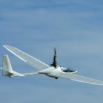 Aeros AC21 Glider in flight cruising across blue sky