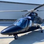 Agusta A109E Power Elite For Sale by Flightline Aviation. Aircraft parked in front of hangar-min