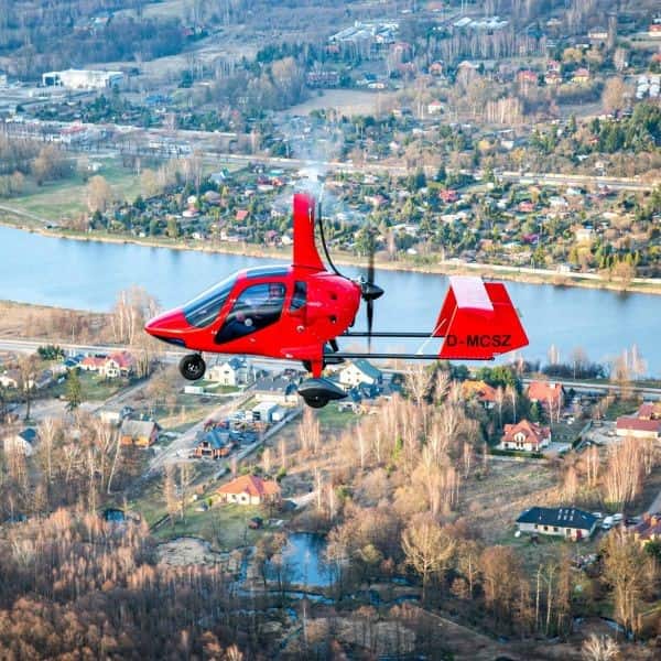 Aviation Artur Trendak gyrocopter in flight over village