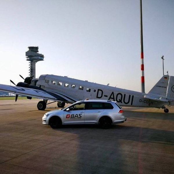 BAS car parked by plane at airport