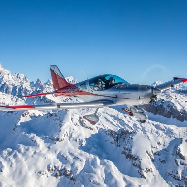 BRM Aero flying above snow capped mountains