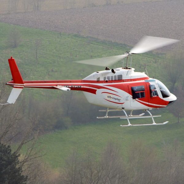 Bell 206 Turbine Helicopter For Hire At STB Copter in flight over fields right side of helicopter