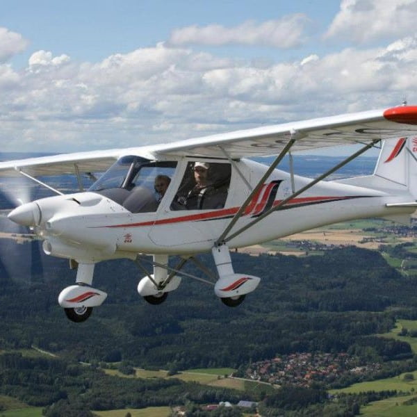 Comco Ikarus plane flying over countryside