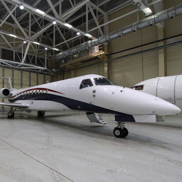Embraer Legacy 650 for charter with AvconJet. Parked in the hangar-min