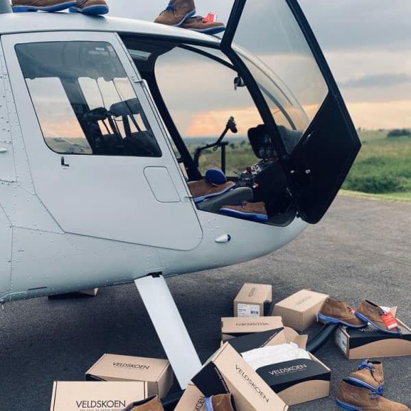 Robinson R44 parked next to shoe boxes-min