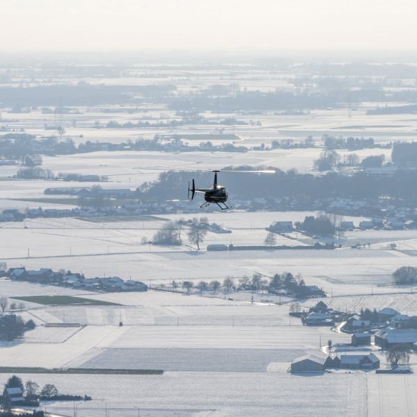STB COPTER on AvPay helicopter flying over snow covered landscape