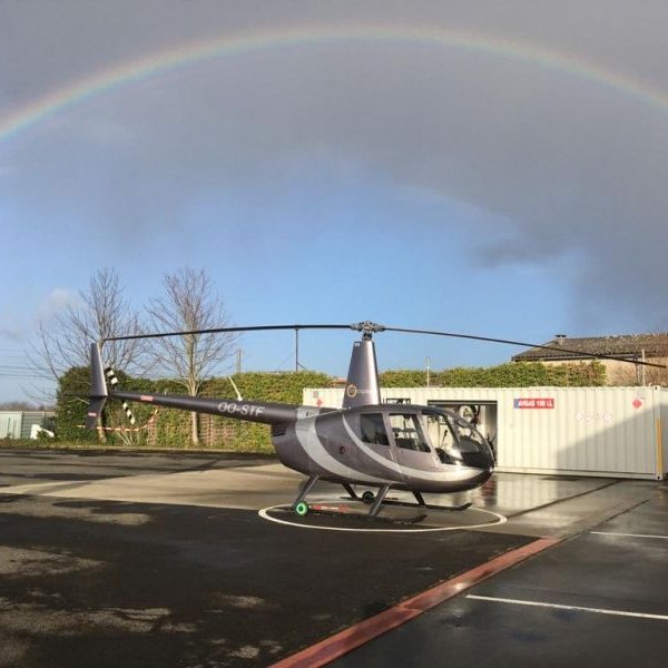 STB COPTER on AvPay helicopter on ground under a rainbow